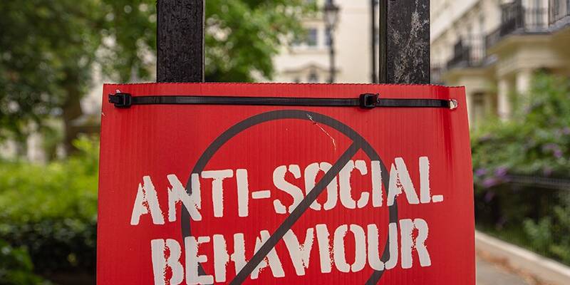 London, United Kingdom - June 25, 2024: Red sign ANTI-SOCIAL BEHAVIOUR crossed out, urban setting.