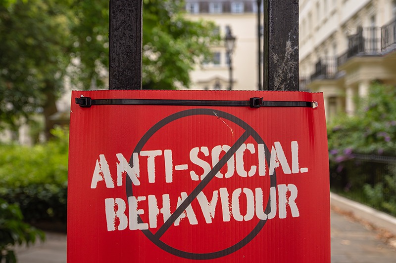 London, United Kingdom - June 25, 2024: Red sign ANTI-SOCIAL BEHAVIOUR crossed out, urban setting.